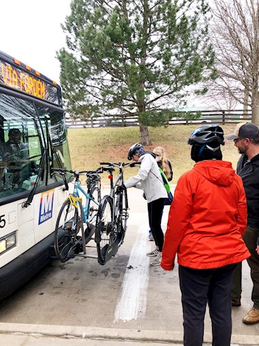 People load bikes onto the bus
