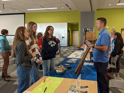 students talking around a display