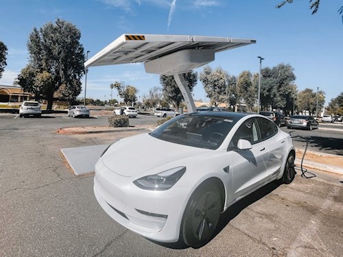 white electric vehicle under solar powered charger