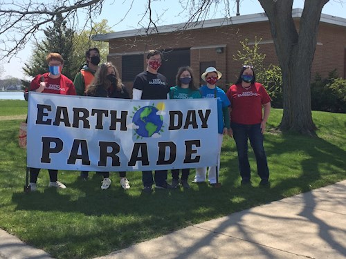People standing behind Earth Day sign