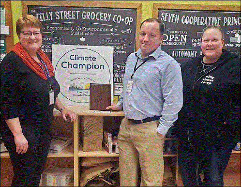 three people in front of climate champion poster