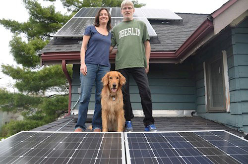 Homeowners stand in front of their new solar energy system