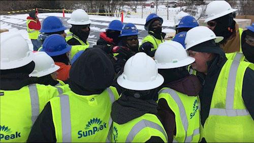 Group of solar installers in team huddle