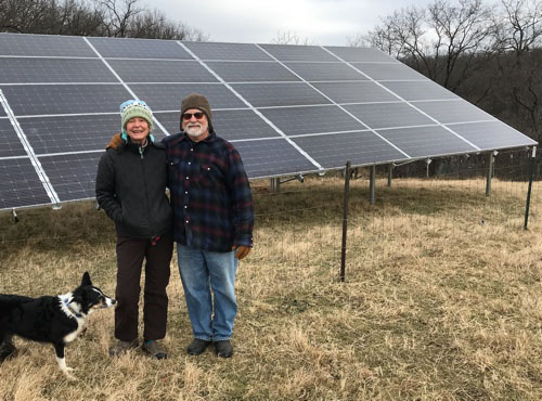 Trish and Jim in front of their solar panels